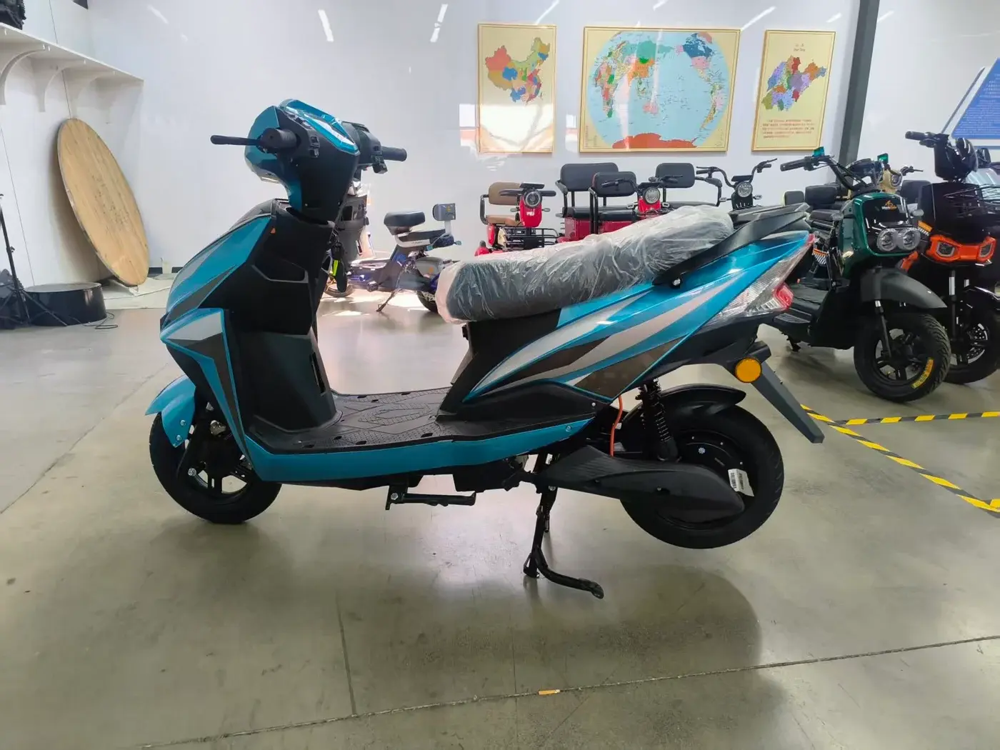 Teal seated electric scooter photographed in a showroom